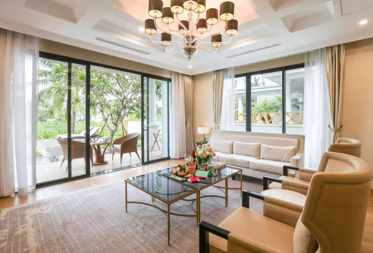 Phòng khách của villa trang trí theo phong cách tân cổ điển kết hợp với cửa sổ cao khiến cho không gian càng trở nên rộng mở.