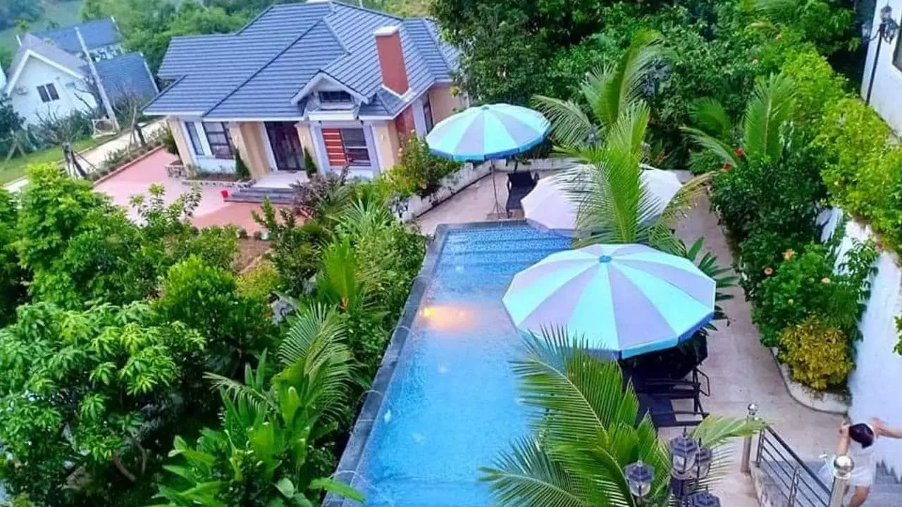 Sunset Villas & Resort Hòa Bình có không gian nhiều cây xanh và bể bơi ngoài trời