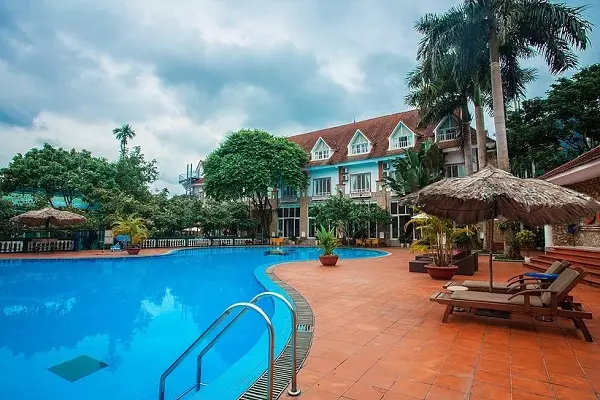 Bể bơi ngoài trời tại Vresort Kim Bôi, với không gian thoáng đãng, được bao quanh bởi cây xanh.